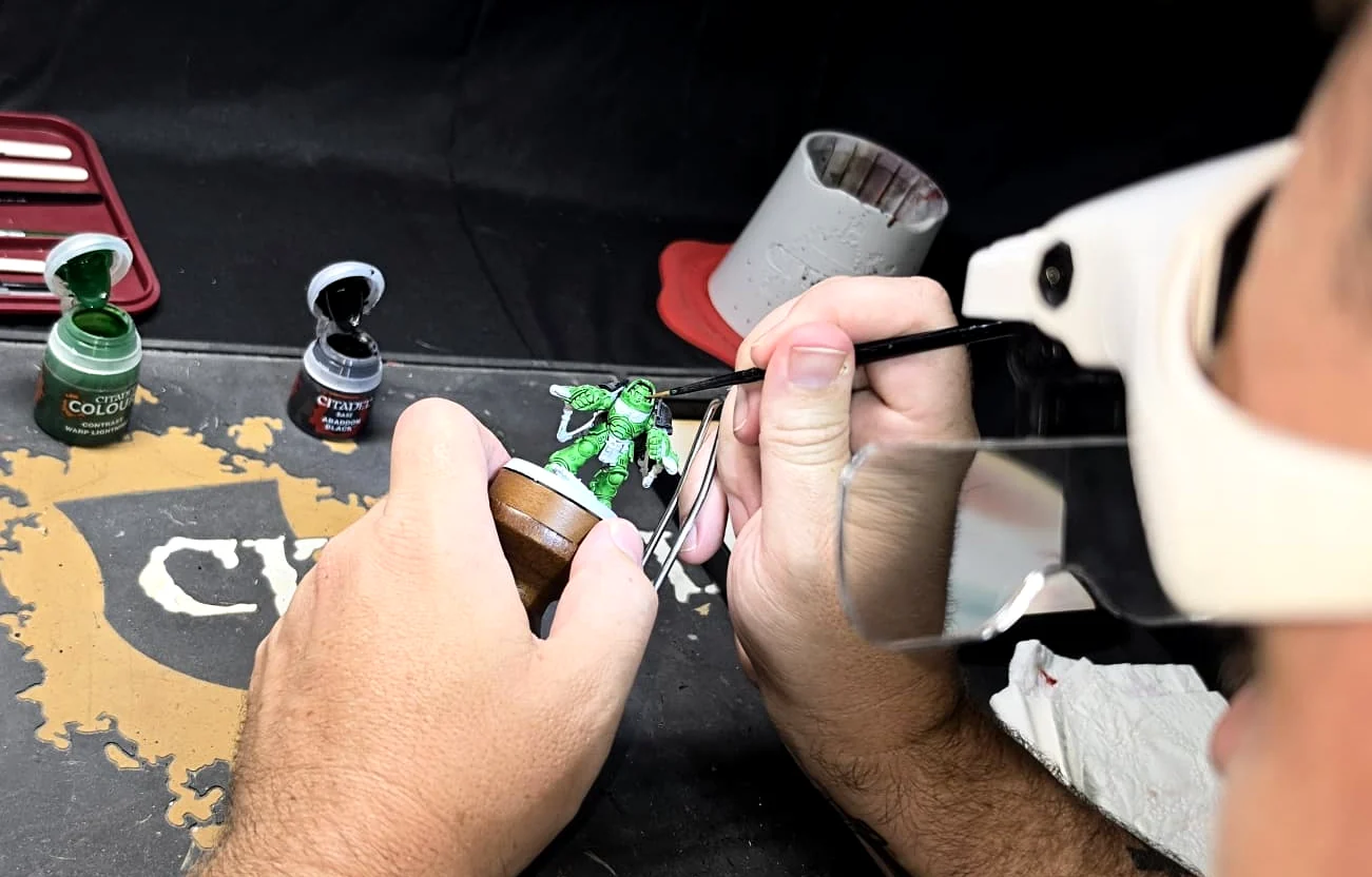 Miniature painting in progress at the Forge Without Limits hobby workspace.